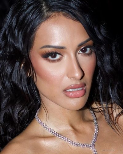 Seerat Saini wearing a red gown with flowing fabric design.