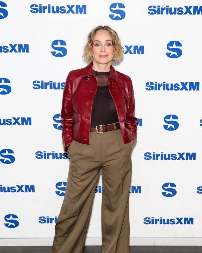 Sharon Stone in simple black top under red leather jacket.