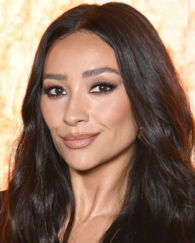 Shay Mitchell in black jumpsuit complemented by gold bracelet