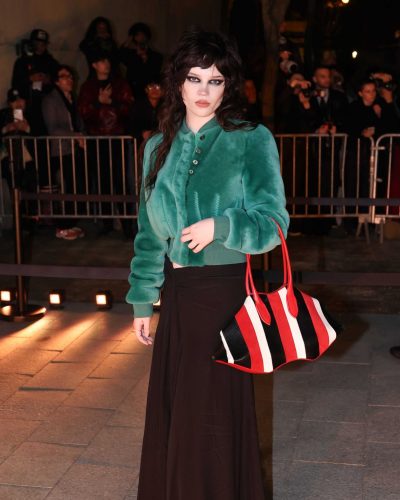 Sophie Thatcher wearing a green bomber jacket with detailed buttoning.