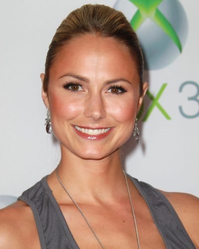 Stacy Keibler gray top and teal skirt accessorized with bracelets.