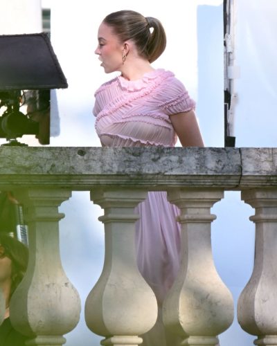 Sydney Sweeney pink gown with gold jewelry in enchanting ambiance.