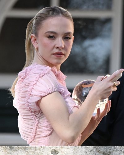 Sydney Sweeney pastel dress with ruffles and natural sunlight backdrop.