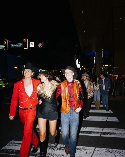 Taylor Hill black boots adding a chic touch to her dress