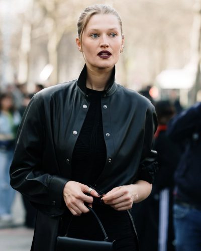Toni Garrn with black leather coat and elegant black outfit.