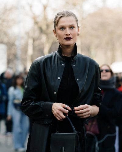 Toni Garrn dressed in black leather coat and chic black pieces.