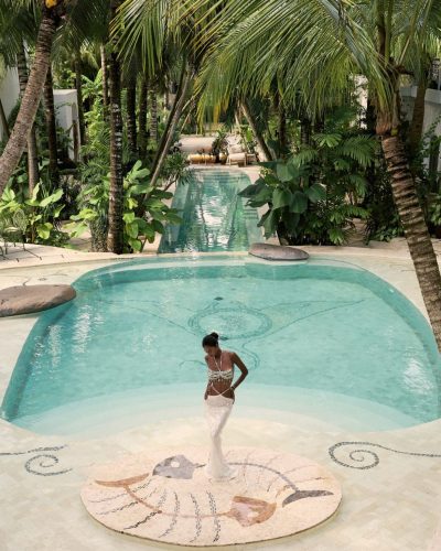 Viktoriia Pandei in layered beach jewelry and aqua top