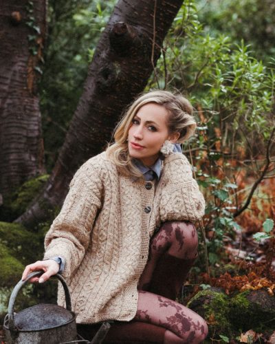 Zibby Allen in chic light-brown cardigan and blue button-up.